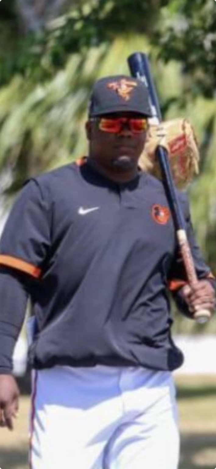 Coach Deiby holding a baseball bat