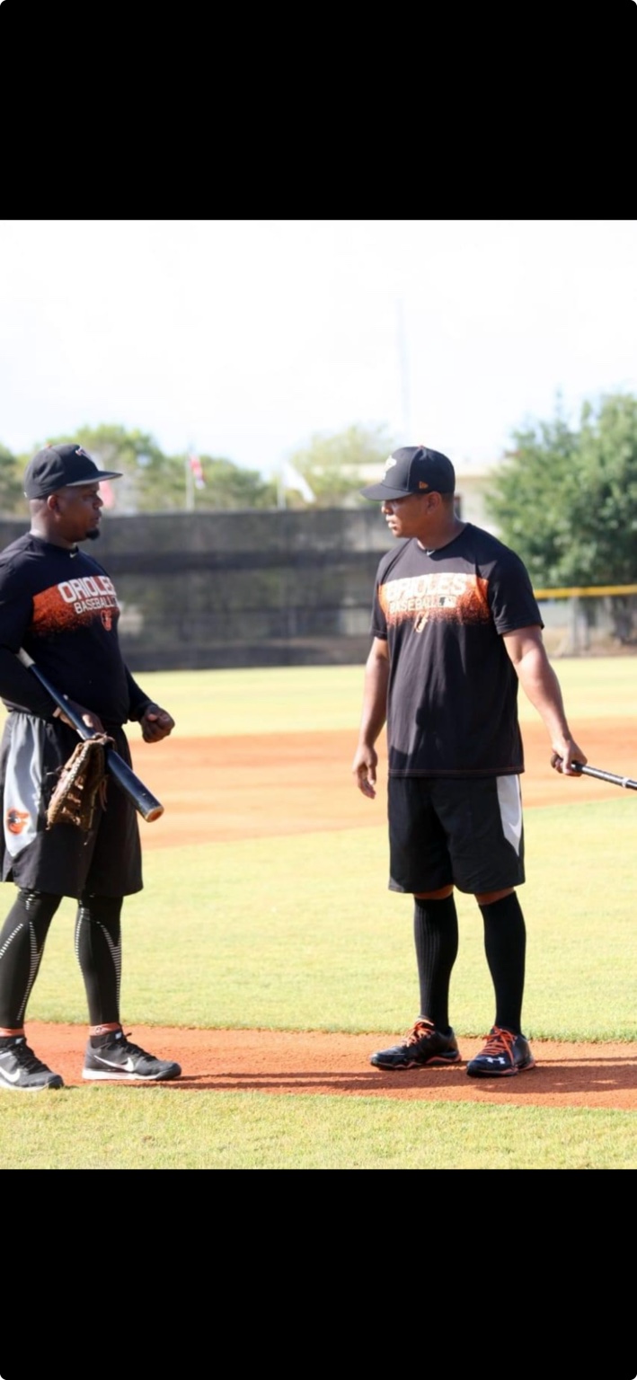 Coach Deiby working with a player during baseball practice